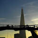 Commuters make their way across the Millennium Bridge as the sun rises over London
